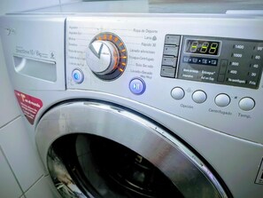 A front view of a washing machine with a digital display, control panel, and various washing options. - Spectacular Golf Course: Newly Remodeled Apartment + Free Parking (Las Condes)