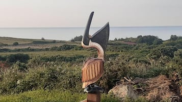 A wooden sculpture of a bird perched on a fence.
