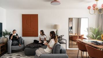 Un salon moderne comprenant un canapé, une table basse et un coin repas avec des chaises.