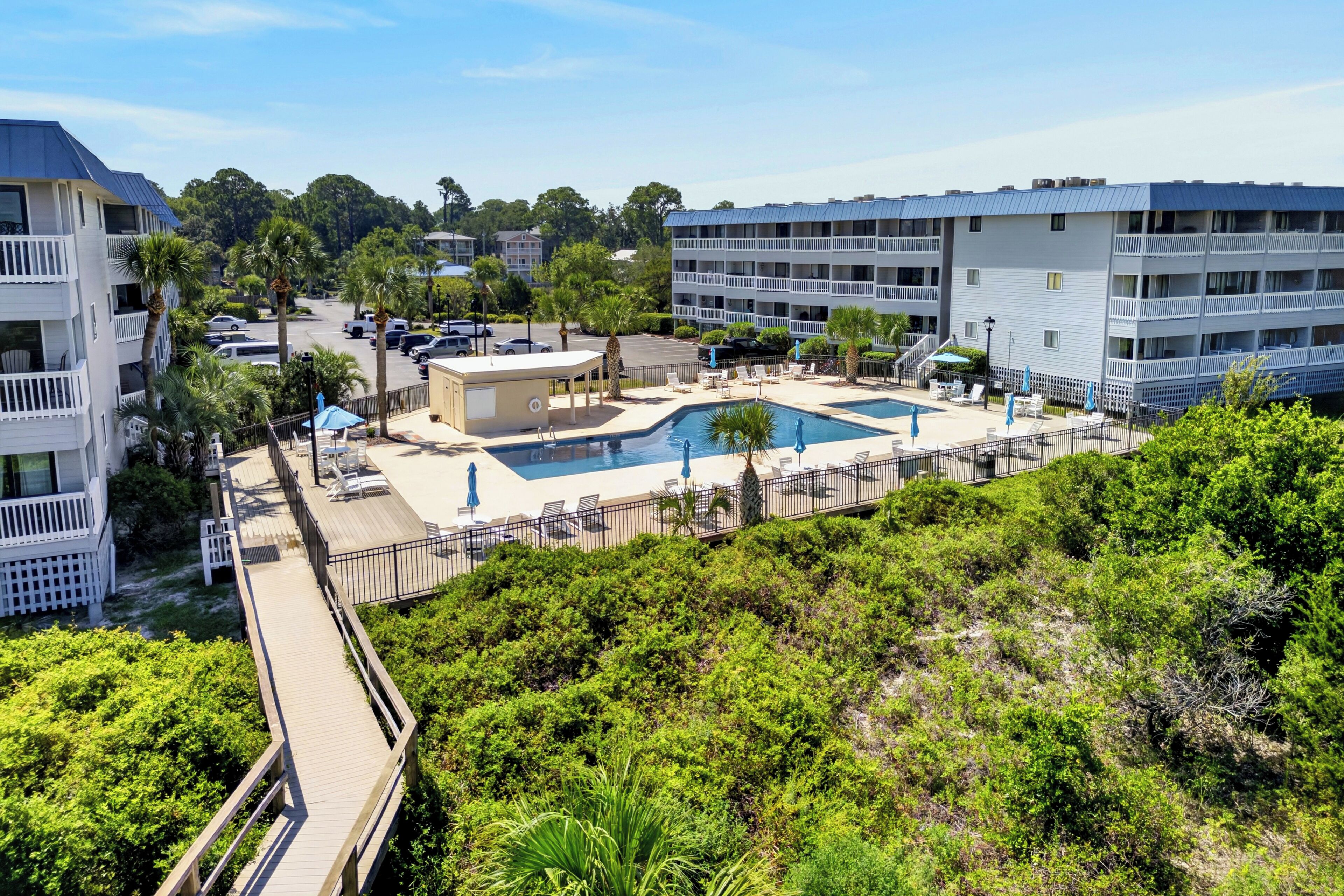 Ein Resort mit Poolbereich, mehreren Balkonen und einem Parkplatz.