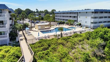 Ein Resort mit Poolbereich, mehreren Balkonen und einem Parkplatz.