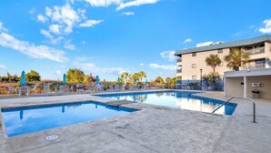 Et poolomr åde med flere pools, liggestole og parasoller.