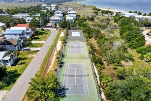 A residential area with multiple houses, a tennis court, and a road. - Cozy by nature and intimate by design. The perfect excuse to stay close and unplug together! (Tybee Island)