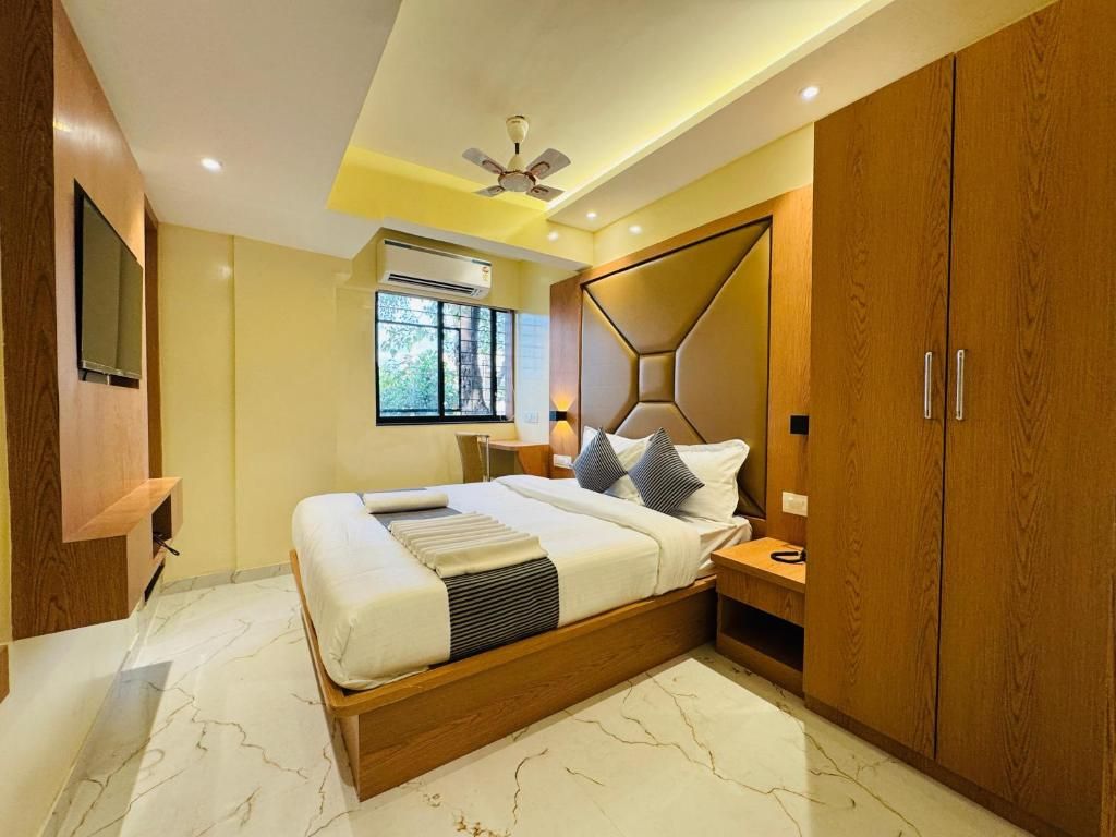 A modern bedroom with a bed, wooden wardrobe, and a ceiling fan.