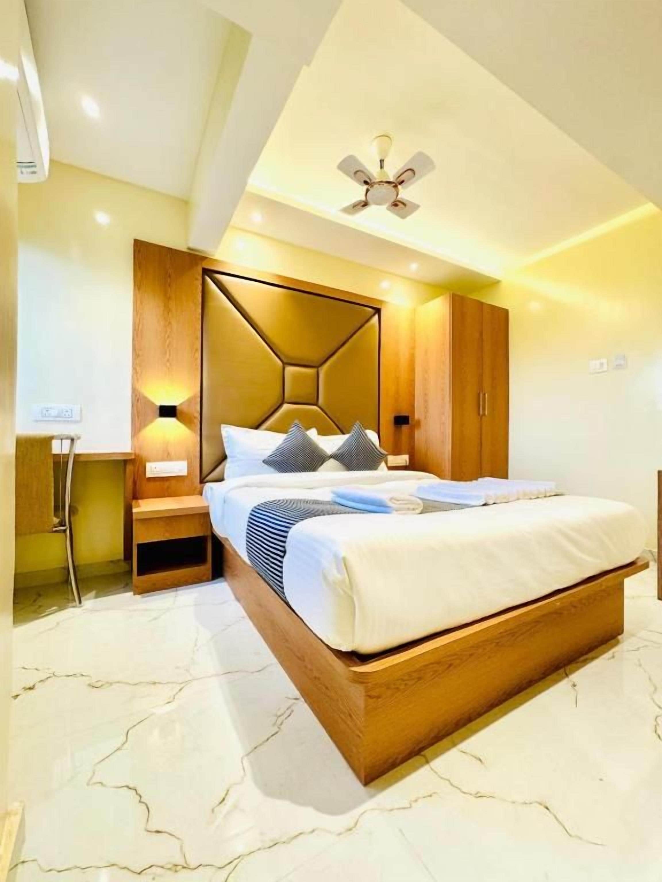 Un dormitorio moderno con cama, mesitas de noche, cabecero de madera y ventilador de techo.