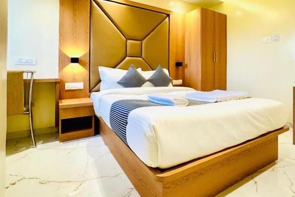 A modern bedroom with a bed, nightstands, a wooden headboard, and a ceiling fan.