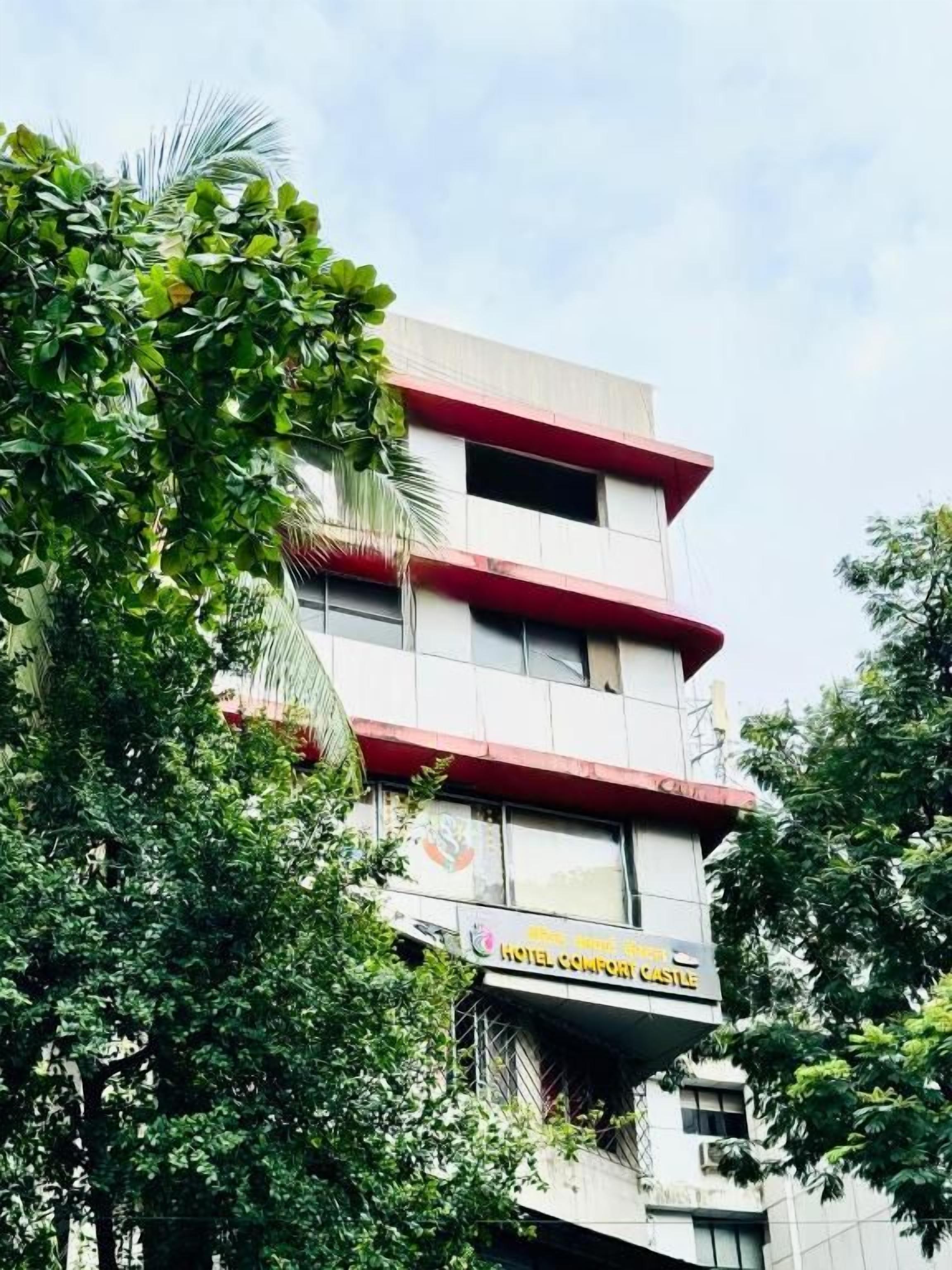 Un immeuble hôtelier à plusieurs étages, doté de balcons et d’une enseigne indiquant qu’il s’agit de l’« hôtel Comfort Castle ».