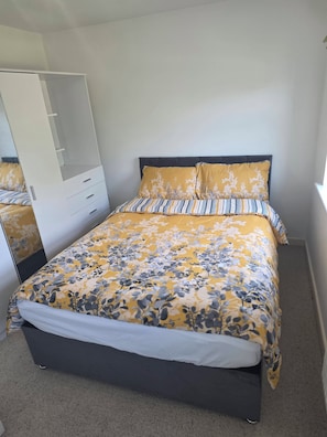 A bedroom with a bed, a wardrobe, and a window. - Shirebrook 2-bed Townhouse, With Free Parking, Ideal for Contractors and Families (Mansfield)