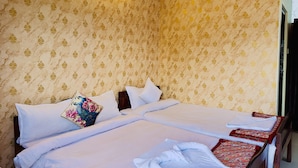 Ein Hotelzimmer mit einem großen Bett, zwei Kissen, einem Nachttisch und einer Wandleuchte.