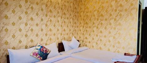 Habitación de hotel con una cama grande, dos almohadas, una mesita de noche y una lámpara de pared.