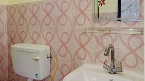 Ein Badezimmer mit Toilette, Waschbecken und einem Spiegel mit Zierrahmen.