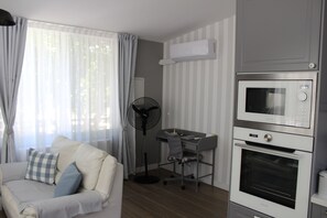 Una kitchenette compacta con microondas, horno y un pequeño escritorio.