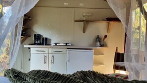 Ein gemütliches Schlafzimmer mit einem Baldachinbett, einer Küchenzeile mit Schränken und einem Essbereich.