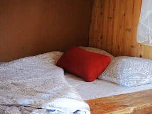 A bed with a patterned blanket, a red pillow, and a patterned pillow. - Camping Ont Moeten - Romney Lodge by Interhome (Rekken)