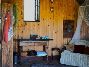 A wooden room with a table, chairs, a bed, and a window. - Camping Ont Moeten - Romney Lodge by Interhome (Rekken)