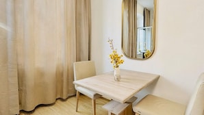 A room with a wooden table, two chairs, a bench, a mirror, and a window with curtains. - 3BR for 9 Near FAC Platz (Vienna)
