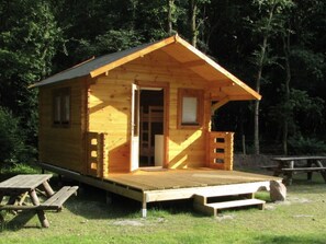 Una baita di legno con un portico, una porta e una finestra.