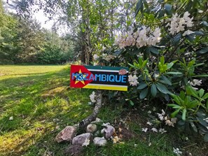 Een bord met de tekst 'MOZAMBIQUE' en een sterrenbeeld, omringd door begroeiing en rotsen.