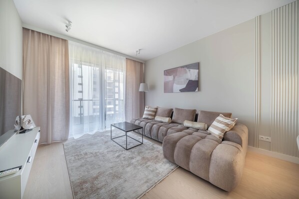 A modern living room with a sofa, a coffee table, and a painting on the wall. - Kierbedzia Beige Elagant, Mokotow, Warsaw (Warszawa)