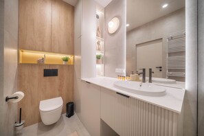 A modern bathroom with a toilet, bidet, vanity with a large mirror, and a sink. - Kierbedzia Beige Elagant, Mokotow, Warsaw (Warszawa)