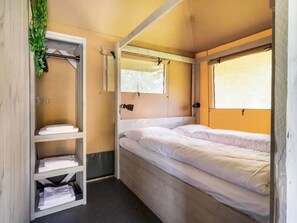 A compact room with a bunk bed, a shelf with folded towels, and a window providing natural light. - De Glamping - Combo Lodge | 5 p lodge + 2 p tent by Interhome (Zeewolde)