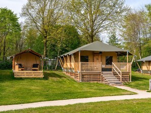 A campsite with two wooden cabins, each with a porch and a door. - De Glamping - 2 1/2 family combo by Interhome (Zeewolde)