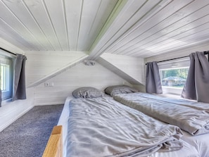 A small, single-room accommodation with a sloped ceiling, two beds, a window, and curtains. - De Glamping - Tiny House rood | 5p by Interhome (Zeewolde)