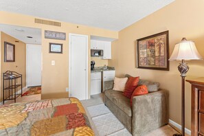 A compact living space with a kitchenette, a sofa, a coffee machine, and a framed artwork on the wall. - S Hampton 1206 3 Br Oceanview in Kingston, Pool (Myrtle Beach)