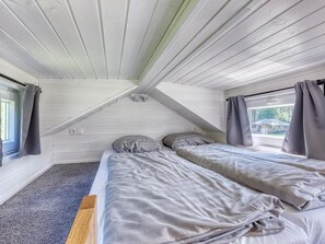 A small, single-room accommodation with a sloped ceiling, two beds, a window, and curtains. - De Glamping - Tiny Safari Geel | 7p by Interhome (Zeewolde)