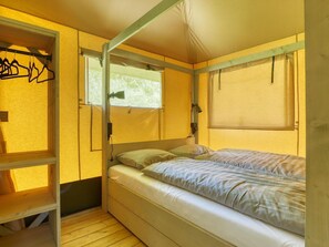A compact room with a bunk bed, a wardrobe, and a window with a view. - De Glamping - Glamping Lodge | 5p by Interhome (Zeewolde)