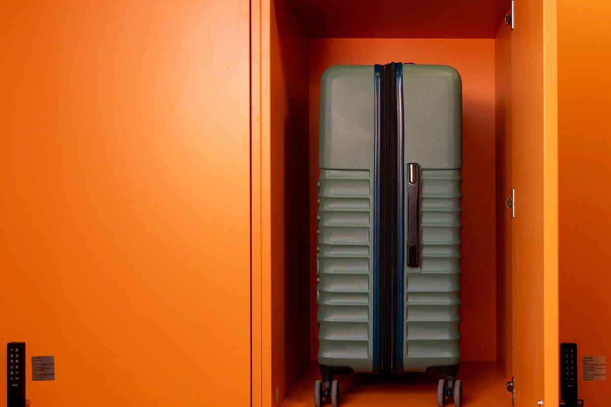 A suitcase in a compartment with a control panel and a lock.