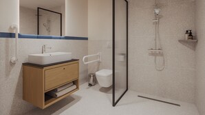 A modern bathroom with a freestanding sink, a toilet, a shower enclosure, and a towel rack.
