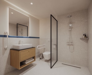 Un baño moderno con lavamanos integrado, inodoro, ducha y espejo.