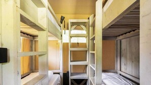 A narrow, enclosed room with bunk beds, a ladder, and a small window. - De Glamping - Trio Lodge | 18p by Interhome (Zeewolde)