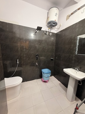 Un baño con inodoro, lavamanos y ducha.