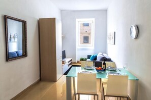 Ein gemütlicher Wohnbereich mit Essplatz, einer Couch und einem Fernseher.