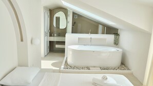 Quarto moderno com uma cama grande, banheira integrada e um claraboia.