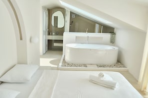 Une chambre à coucher moderne avec un grand lit, une baignoire intégrée et une lucarne.