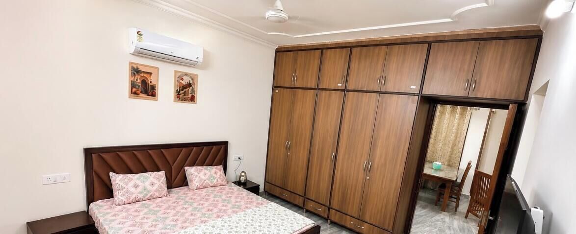 Een slaapkamer met een bed, een kledingkast en een plafondventilator.