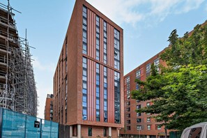 A modern high-rise building with multiple floors, large windows, and a brick facade. - Host Stay Miller s Place Apartment (Liverpool)
