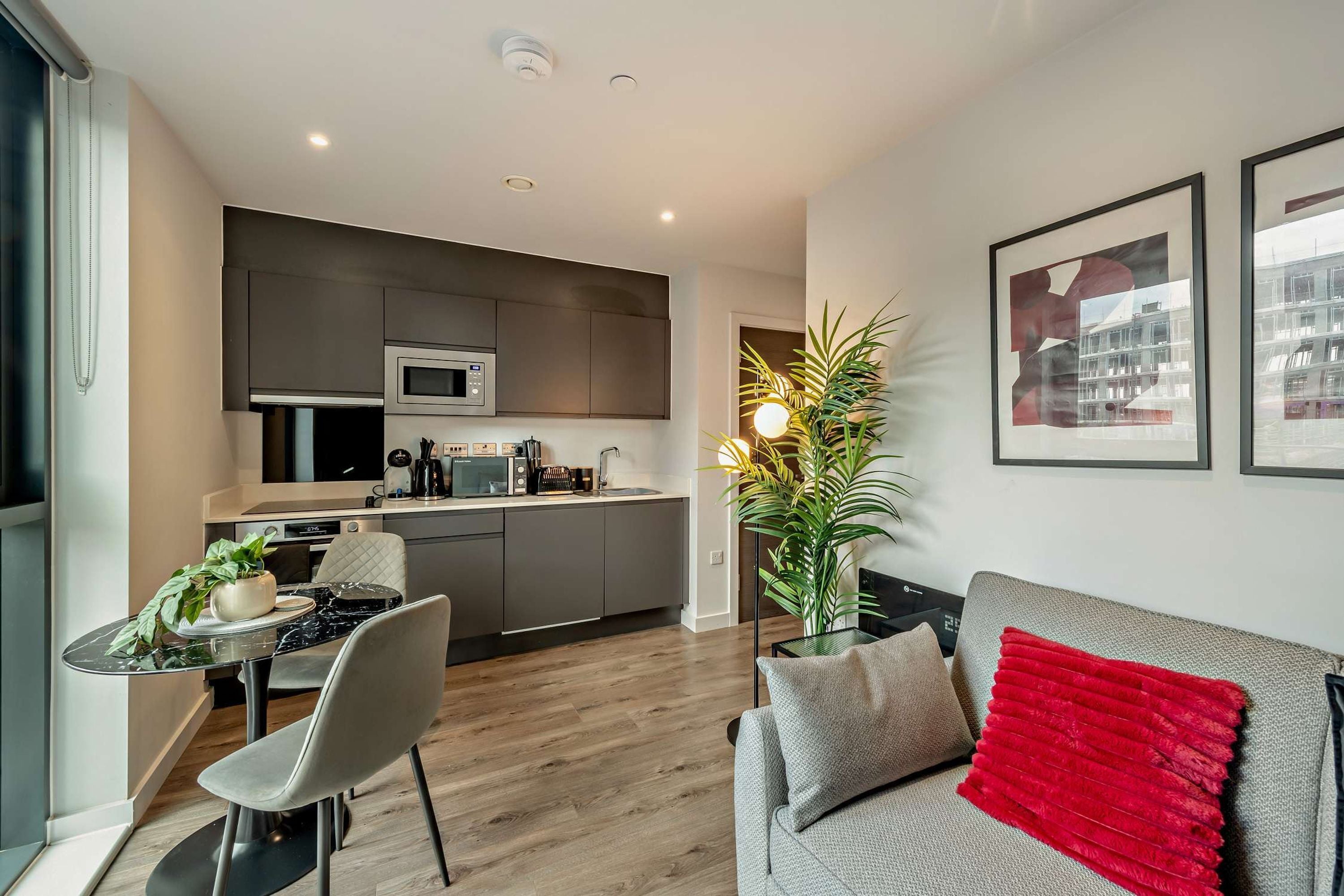 Een modern appartement met keuken, eethoek en woonkamer.