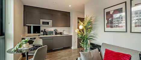 A modern apartment with a kitchen, dining area, and living room.