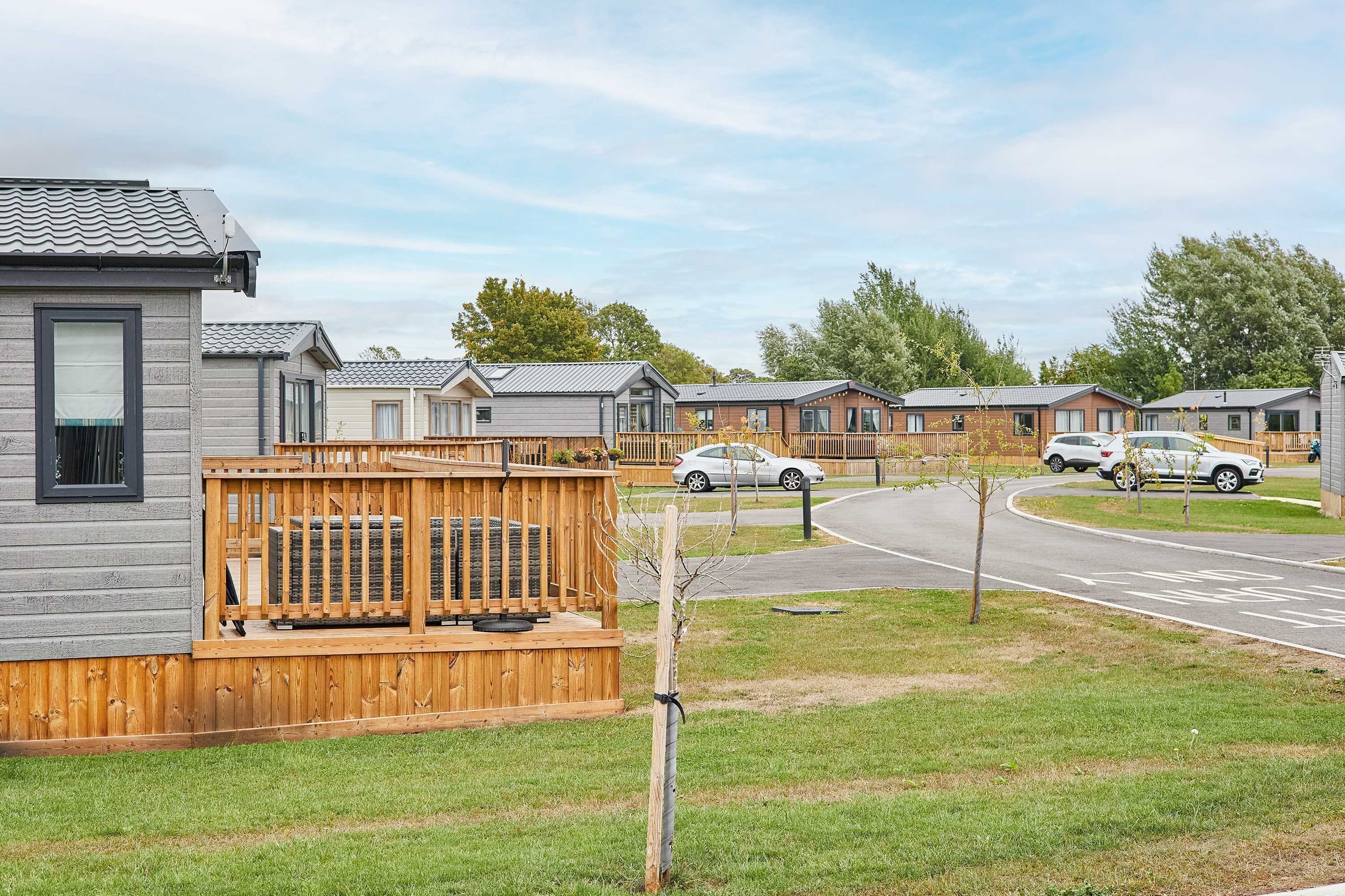 A row of mobile homes with a wooden deck in the foreground.