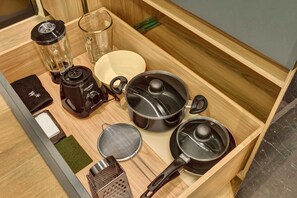 A kitchen drawer with various utensils and appliances, including a blender, pots, a strainer, and a grater. - w Charming 1BR in the Heart of Zona T (Bogotá)
