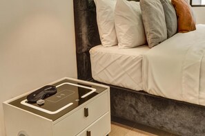 A neatly made bed with a dark headboard, a bedside table with a charging station, and a small drawer. - w Charming 1BR in the Heart of Zona T (Bogotá)