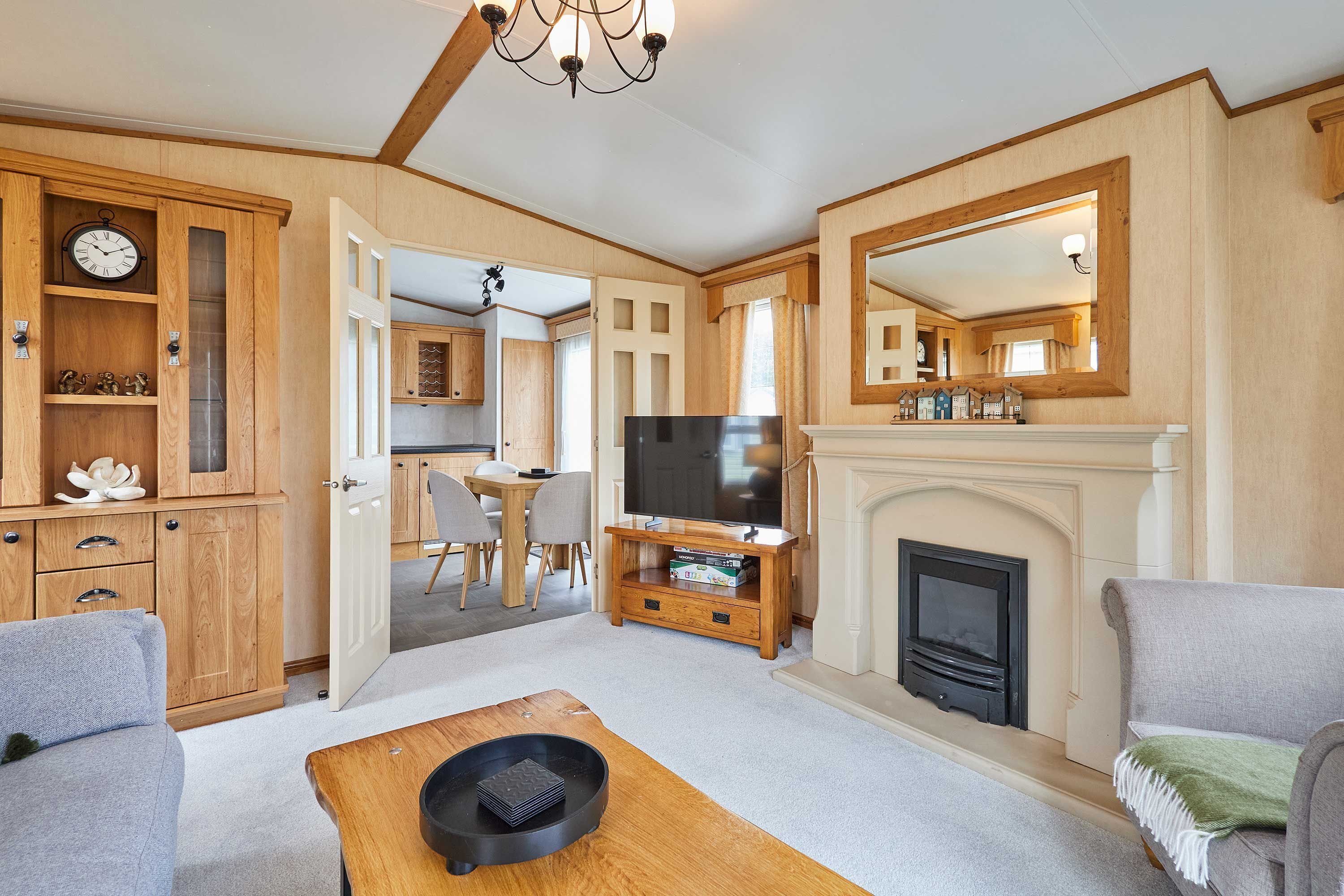 A living room with a fireplace, a television, and a dining area with chairs and a table.