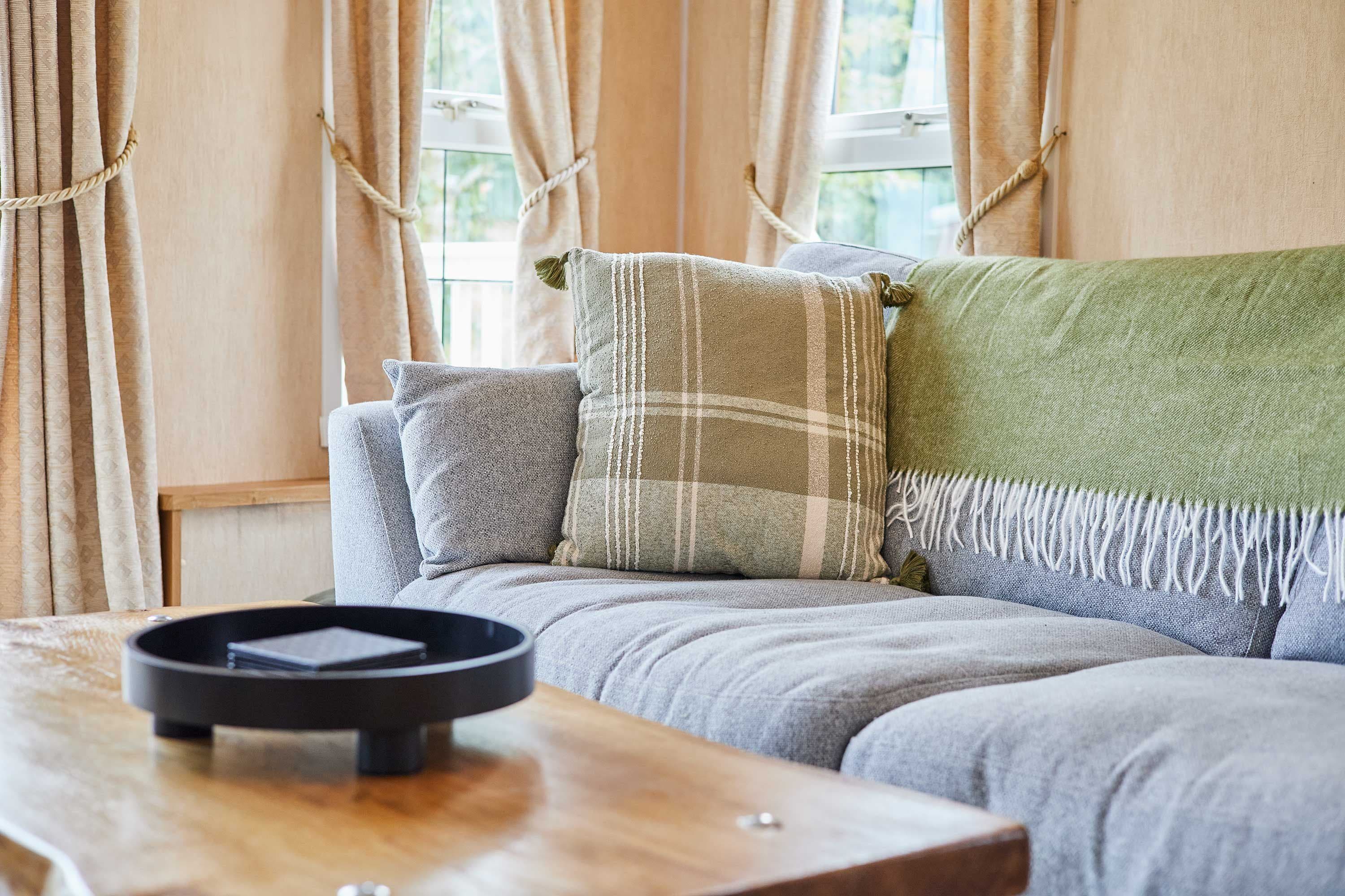 A cozy living room with a sofa, pillows, and a wooden coffee table.