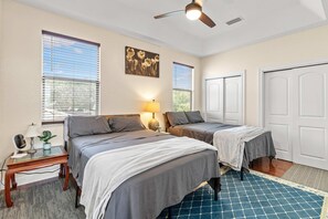 A bedroom with two beds, a ceiling fan, and a window with blinds. - 4BR Escape 10 Mins to Madeira Clearwater Beach (Pinellas Park)