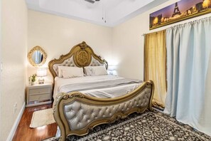 Ein Schlafzimmer mit einem großen Bett, einem Nachttisch, einem Spiegel und einem Stadtbild.