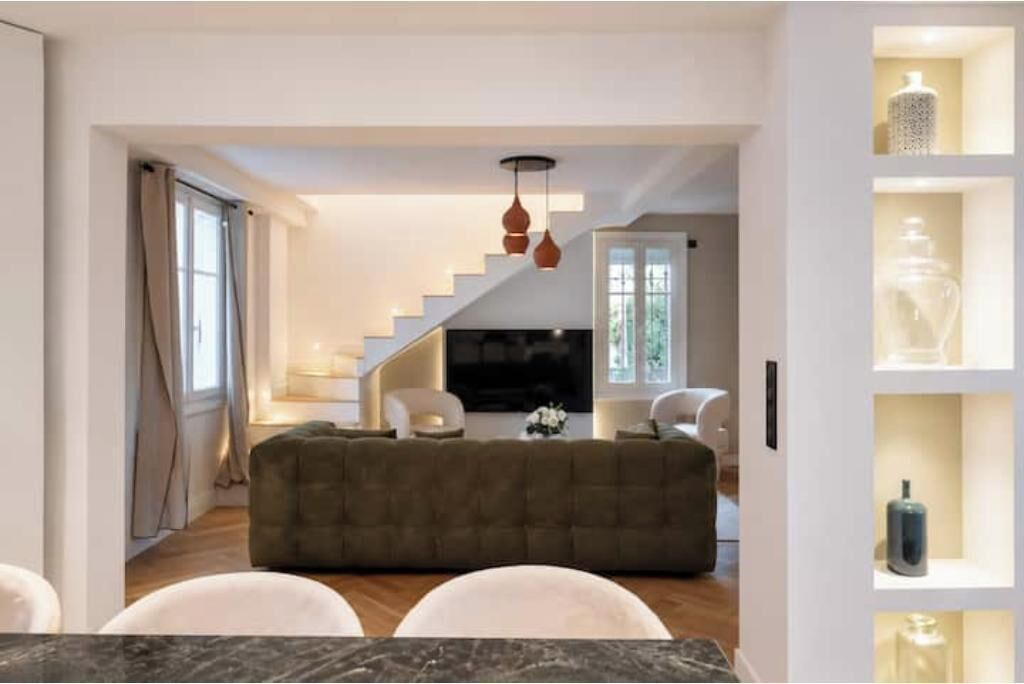 Un salon moderne avec un escalier, un canapé et une table basse.